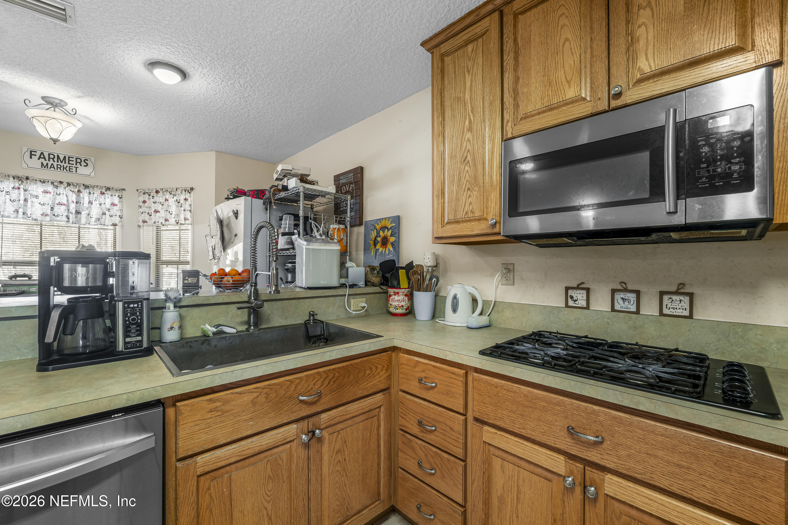 1725 Davidson Farm Road Jacksonville, FL 32218 - Photo 27 of 55 a kitchen with stainless steel appliances granite countertop a stove a microwave and cabinets
