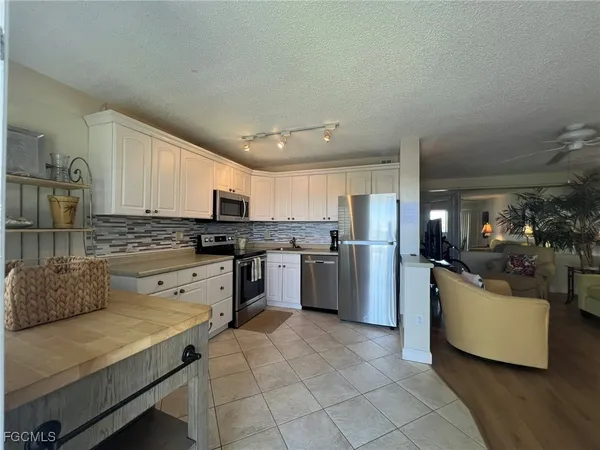 a kitchen with stainless steel appliances granite countertop a refrigerator sink and stove