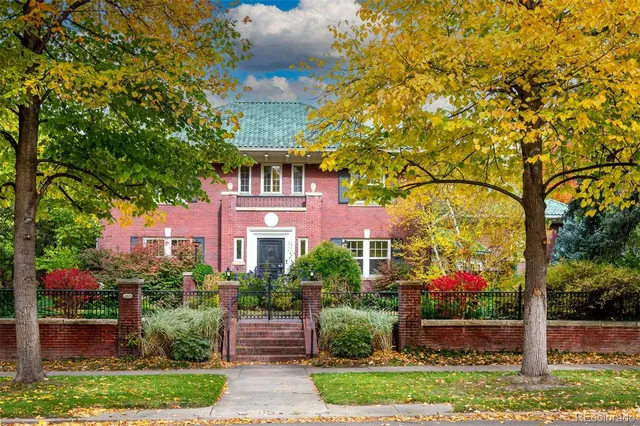a front view of a house with a yard and potted plants