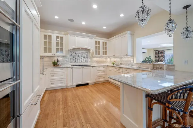 a kitchen with stainless steel appliances granite countertop a sink dishwasher and a stove with wooden floor