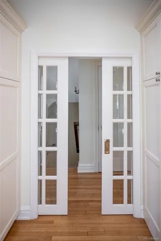 a view of an empty room with wooden floor and windows