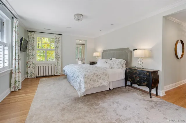a spacious bedroom with a bed a dresser next to a window