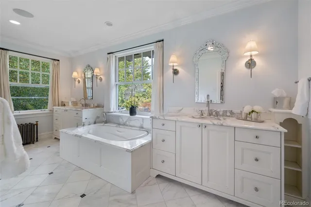 a bathroom with a sink double vanity mirror and a bathtub