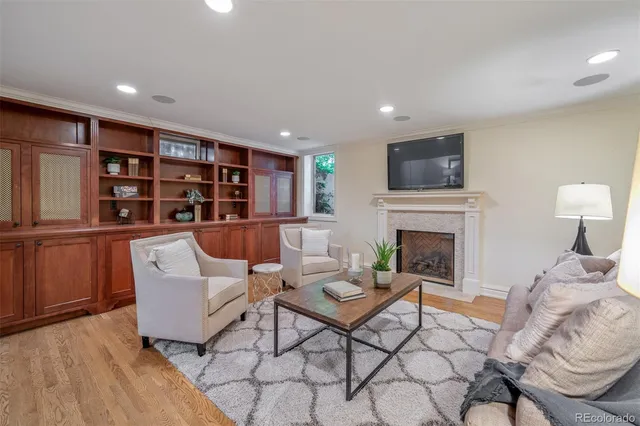 a living room with furniture a fireplace and a flat screen tv