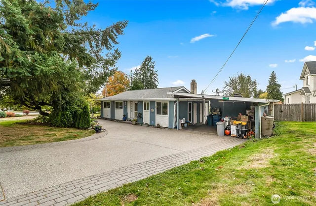 a view of a house with backyard and sitting area