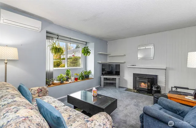 a living room with furniture fireplace and a large window