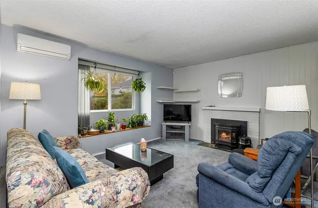 a living room with furniture fireplace and a large window