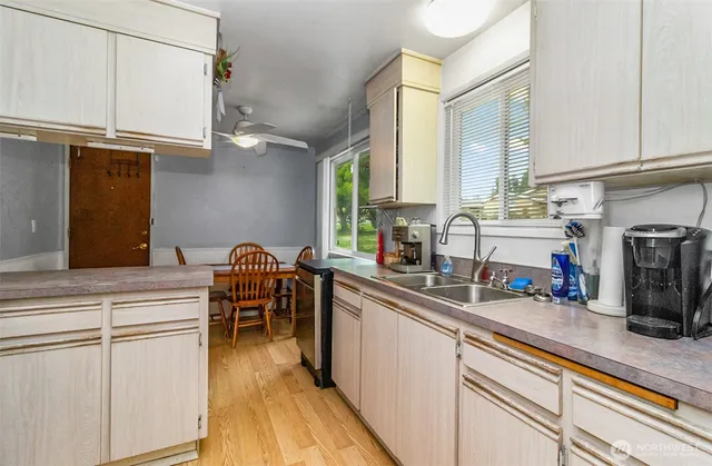 a kitchen with kitchen island granite countertop a sink appliances cabinets and a counter top space