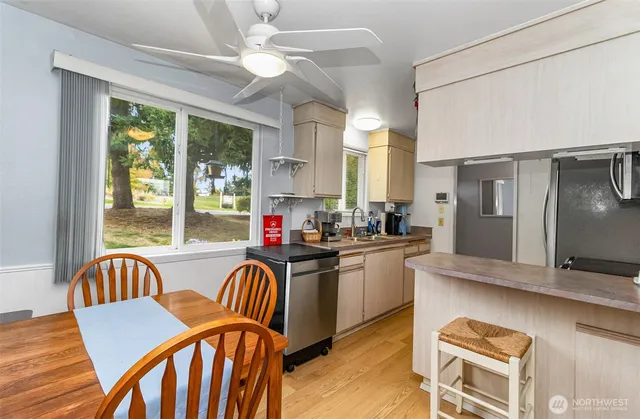 a kitchen with granite countertop a table chairs stove and refrigerator