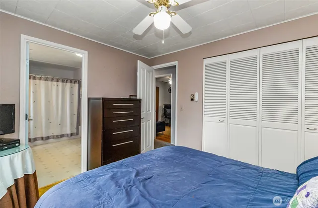 a bedroom with a bed and a flat tv screen on dresser