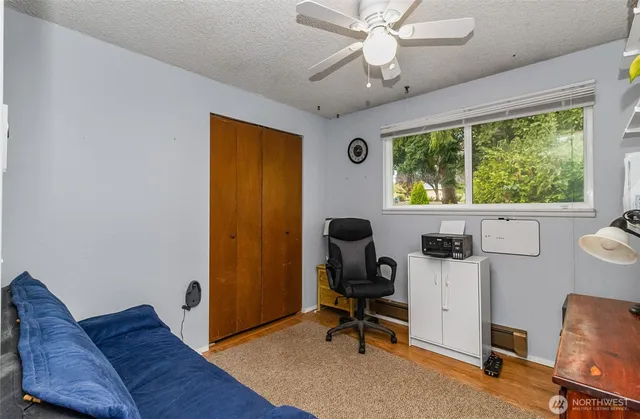 a view of a workspace with furniture and a window