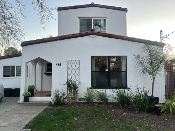a front view of a house with a garden and plants