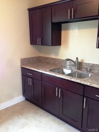 a kitchen with granite countertop wood cabinets
