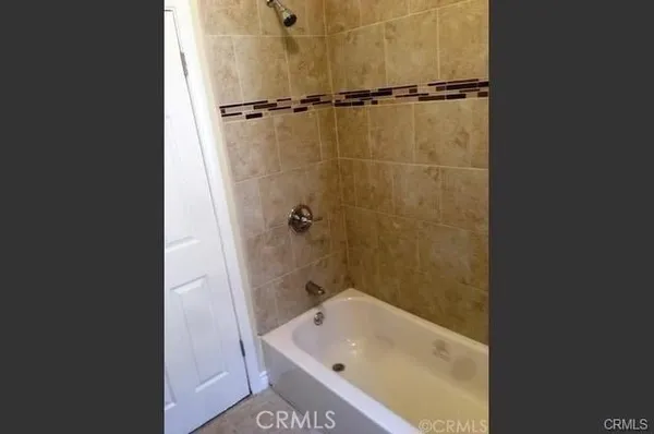 a bathroom with a tub sink vanity and shower