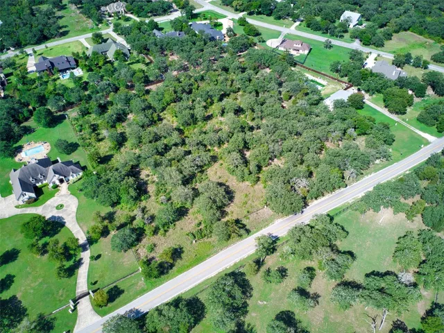 a view of a green yard with large trees