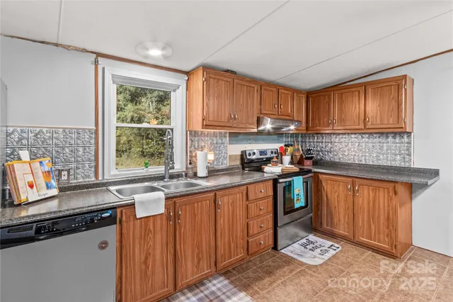 a kitchen with granite countertop a sink stove top oven and cabinets