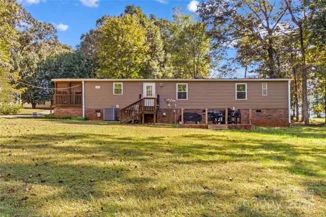 a view of a swimming pool with lawn chairs and plants