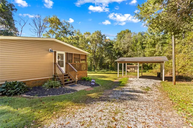 a view of a house with backyard and sitting area