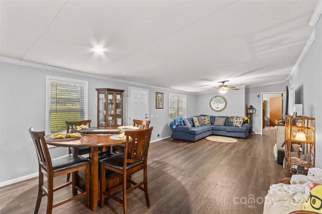a view of a dining room and livingroom with furniture wooden floor and a rug