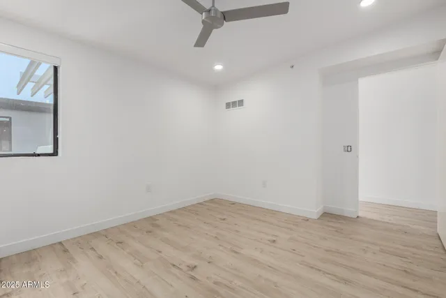 a view of a room with wooden floor and ceiling fan