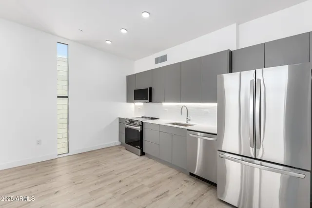 a kitchen with stainless steel appliances a refrigerator and a sink