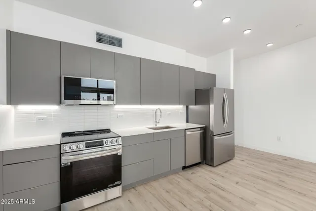 a kitchen with stainless steel appliances a refrigerator sink and microwave