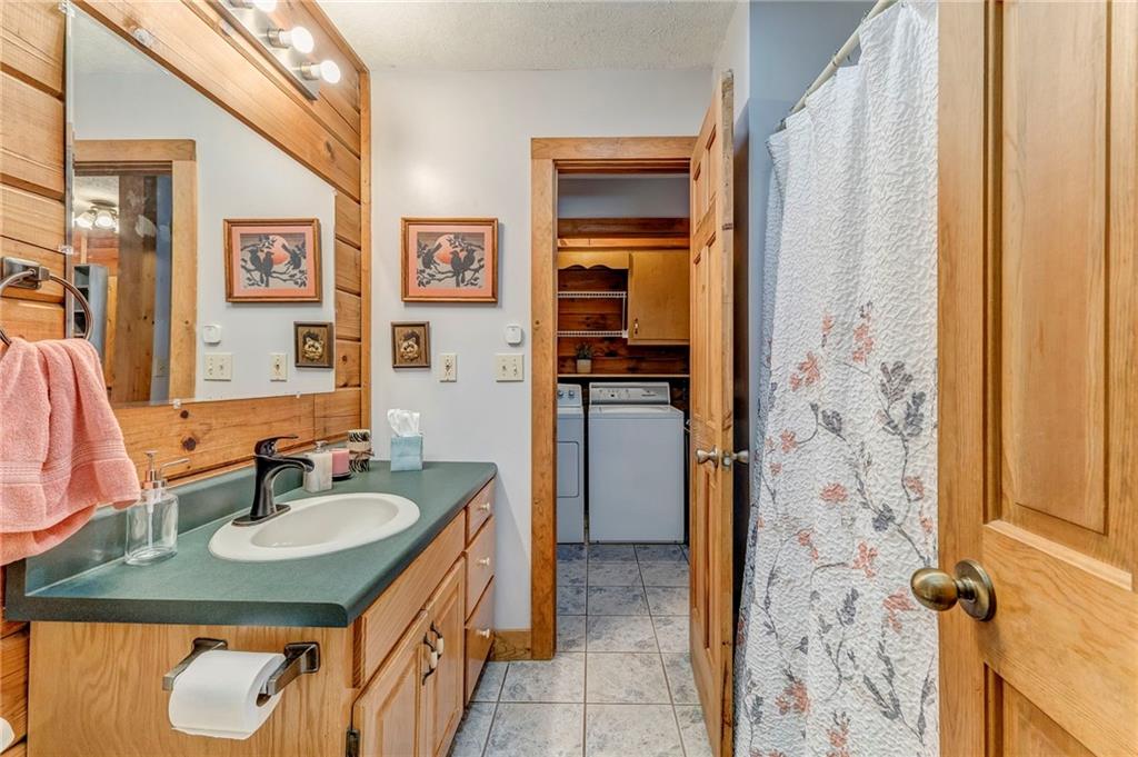 4569 Old Dalton Road Northeast Rome, GA 30165 - Photo 28 of 53 a bathroom with a granite countertop sink a mirror a shower and a sink