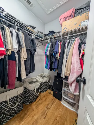 a view of walk in closet with clothes and shoes