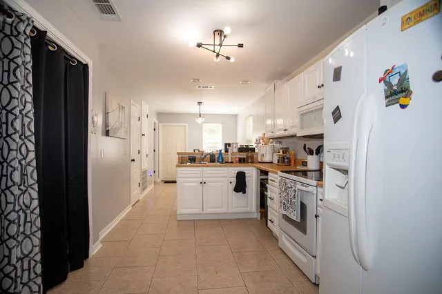 a kitchen with white cabinets and white appliances