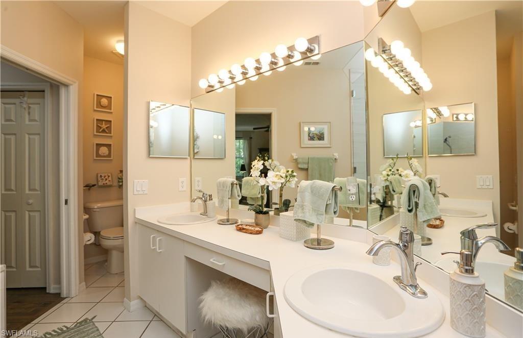 3775 Fieldstone Boulevard, Unit 102 Naples, FL 34109 - Photo 14 of 27 a bathroom with a sink and a mirror