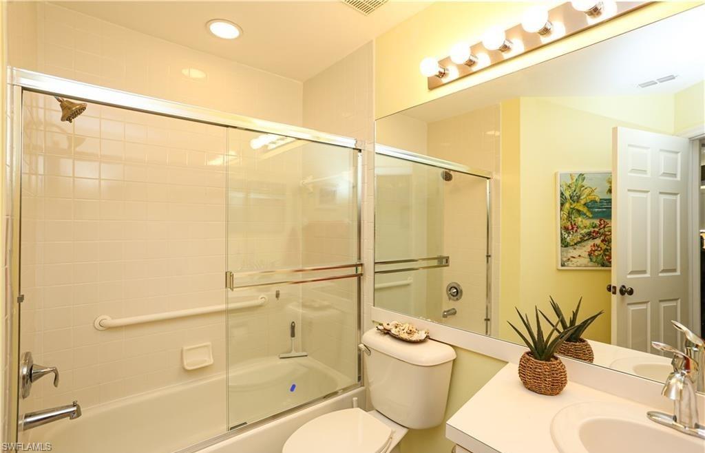 3775 Fieldstone Boulevard, Unit 102 Naples, FL 34109 - Photo 18 of 27 a bathroom with a shower a sink and a mirror