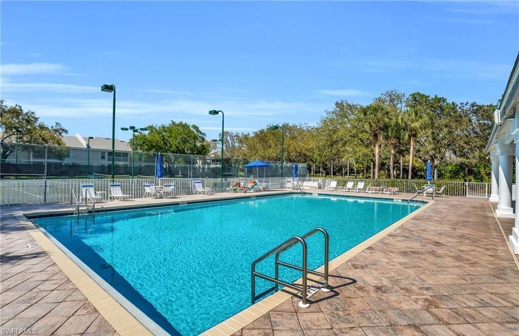 3775 Fieldstone Boulevard, Unit 102 Naples, FL 34109 - Photo 24 of 27 a view of a swimming pool with a lawn chairs
