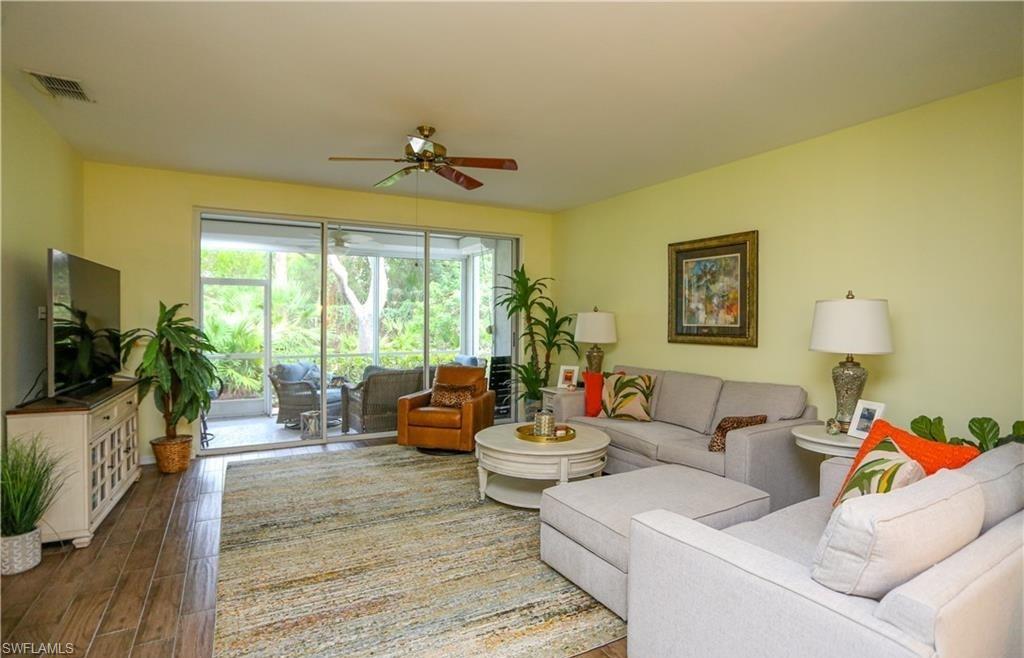 3775 Fieldstone Boulevard, Unit 102 Naples, FL 34109 - Photo 6 of 27 a living room with furniture and a flat screen tv