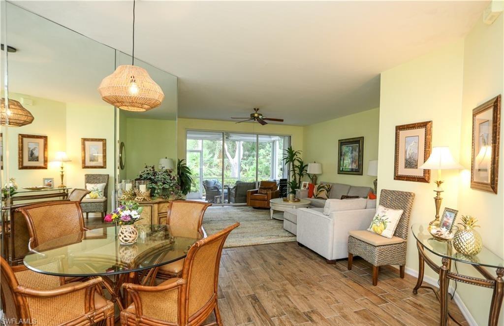 3775 Fieldstone Boulevard, Unit 102 Naples, FL 34109 - Photo 7 of 27 a living room with fireplace furniture and a chandelier
