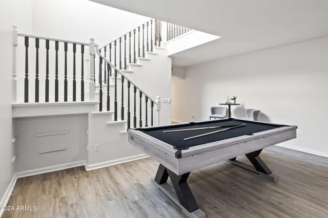 a living room with a table chairs and stairs