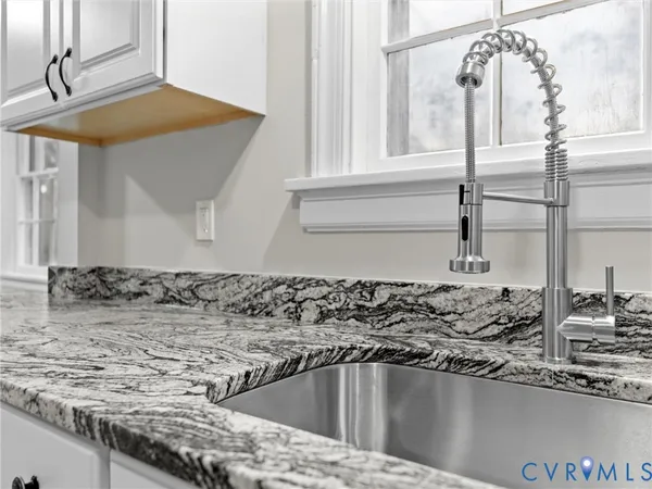 a view of a kitchen sink a faucet cabinets and a counter top space