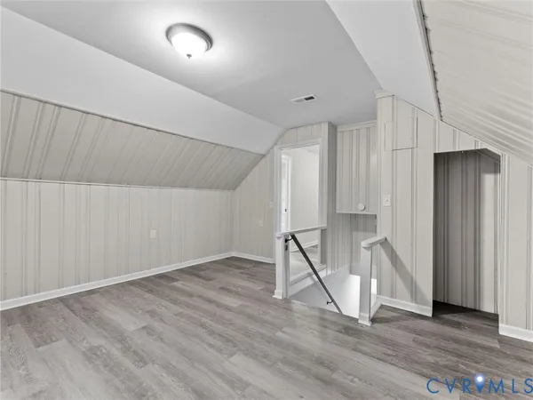 an empty room with wooden floor and entrance