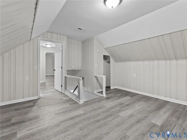 an empty room with wooden floor and mirror