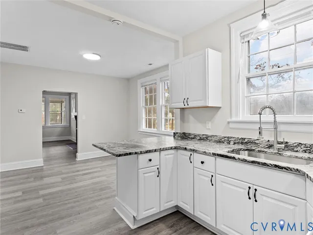 a kitchen with granite countertop wooden cabinets and white appliances