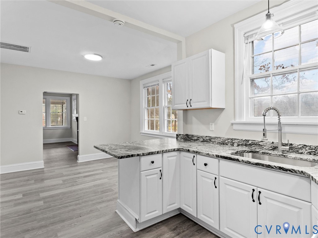 3928 East Broad Rock Road Richmond, VA 23224 - Photo 7 of 34 a kitchen with granite countertop wooden cabinets and white appliances