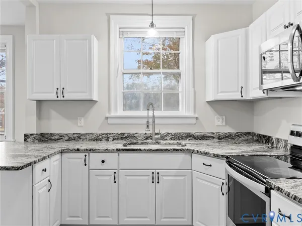 a kitchen with stainless steel appliances granite countertop a sink stove and cabinets