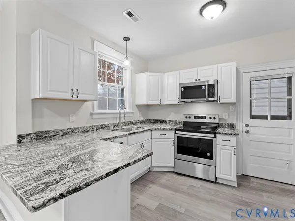 a kitchen with stainless steel appliances granite countertop a stove a sink and a granite counter tops