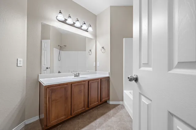 a bathroom with a double vanity sink and mirror with shower