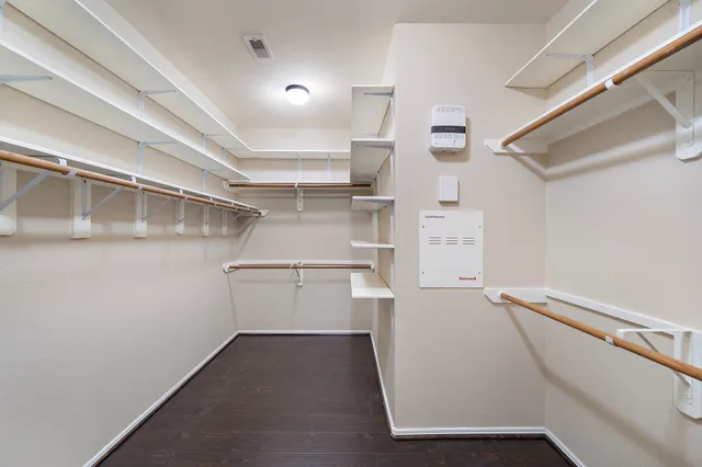 a view of walk in closet with empty racks