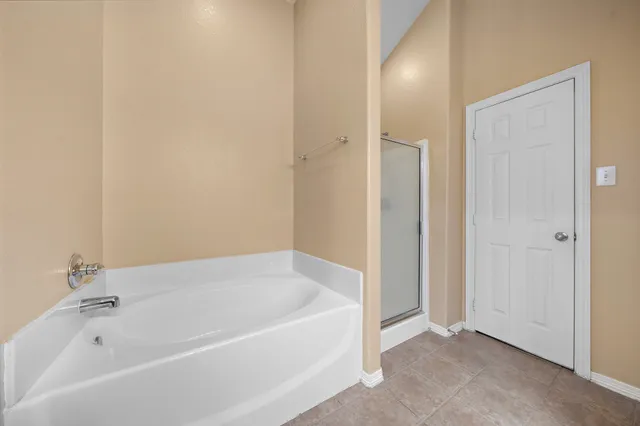 a white bath tub sitting in a bathroom and mirror