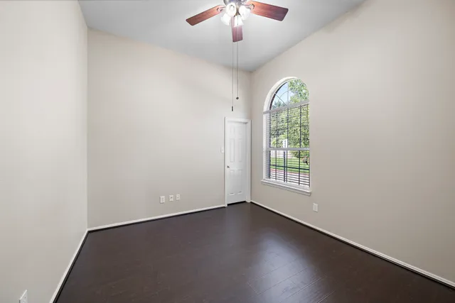 an empty room with a window and wooden floor