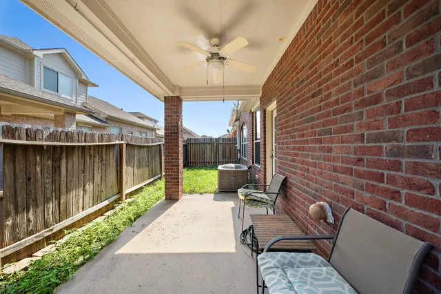 a view of a patio with a table chairs and a floor to ceiling window