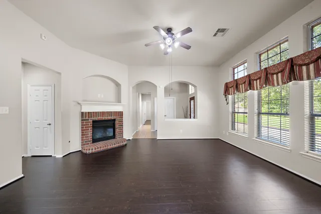a view of empty room with fireplace and wooden floor