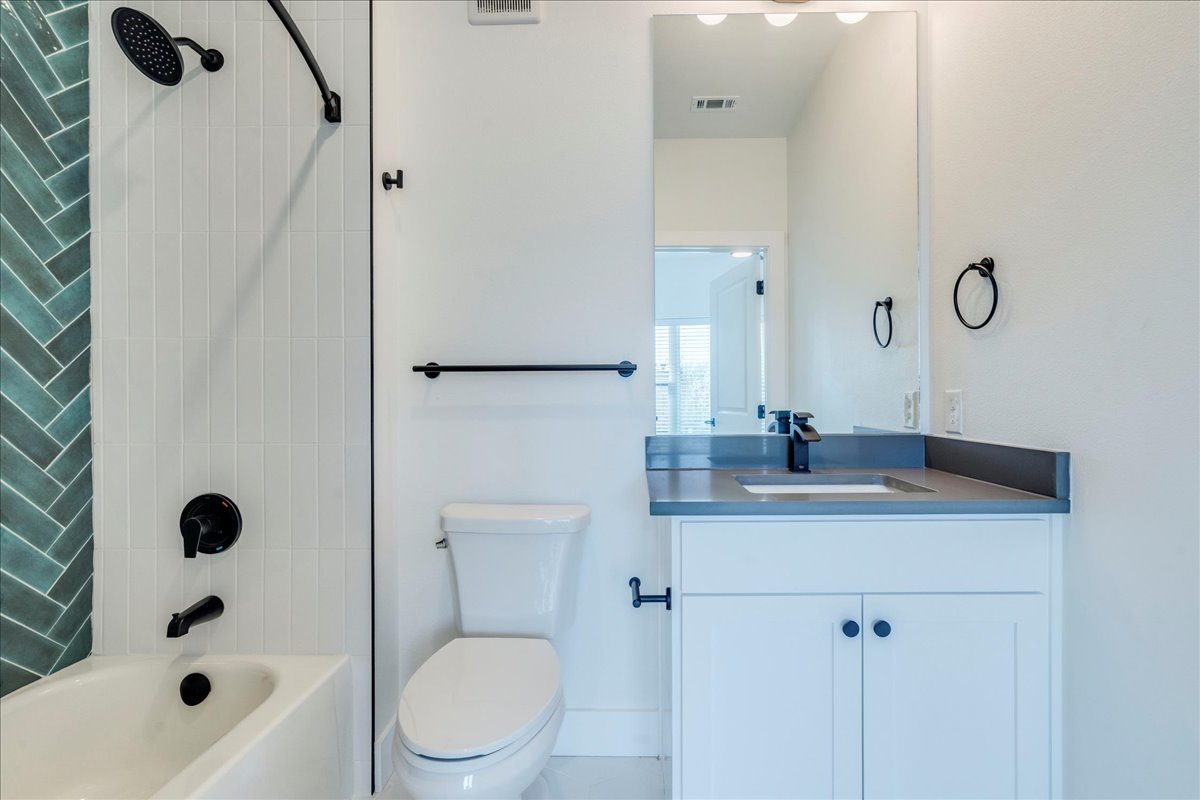 3000 Duval Street, Unit 203 Austin, TX 78705 - Photo 9 of 27 a bathroom with a granite countertop sink toilet a shower and a mirror