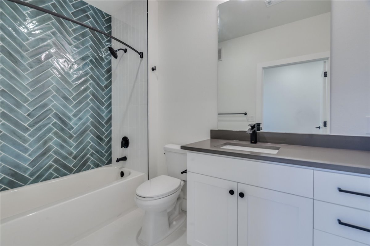 3000 Duval Street, Unit 203 Austin, TX 78705 - Photo 18 of 27 a bathroom with a granite countertop sink a toilet and shower